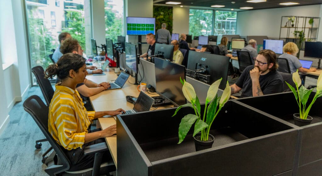 Ideal Managed Services team in the Brighton offices working at computers and taking support calls.