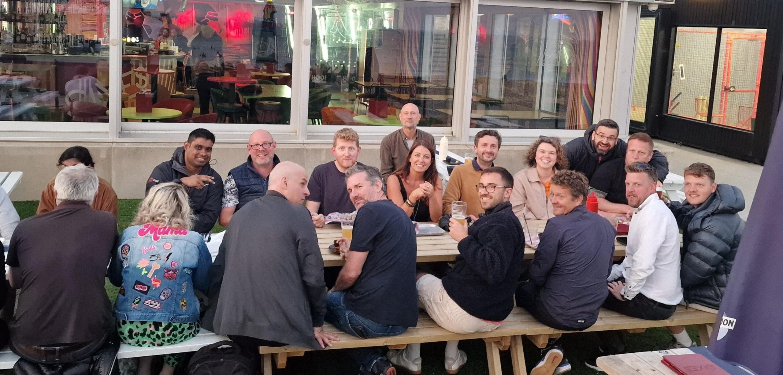 Some of the Ideal team sitting on benches at an Ideal social event.