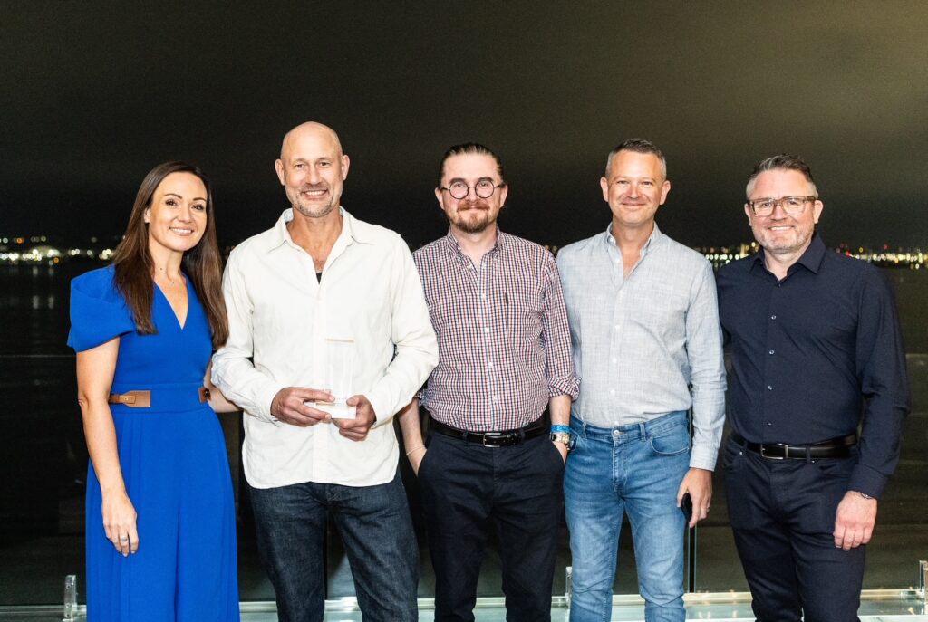 Moto Shakoori hold teh Award flanked by 4 other people.